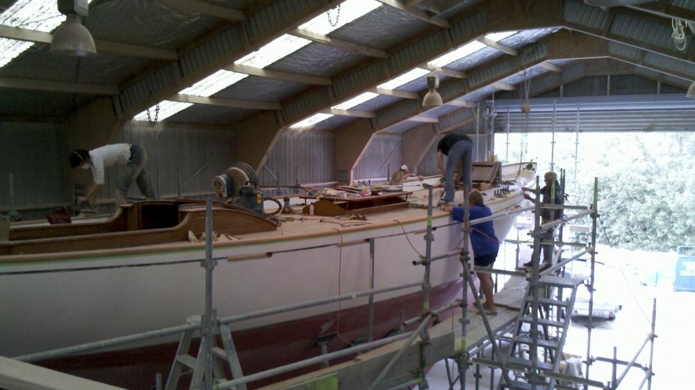 Many volunteer hands working on the cap rail.