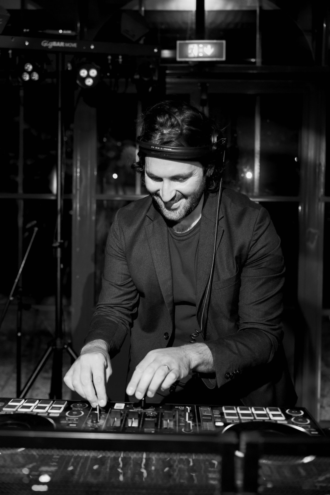 Mat the DJ behind the decks, headphones on, mixing at a private event on the French Riviera