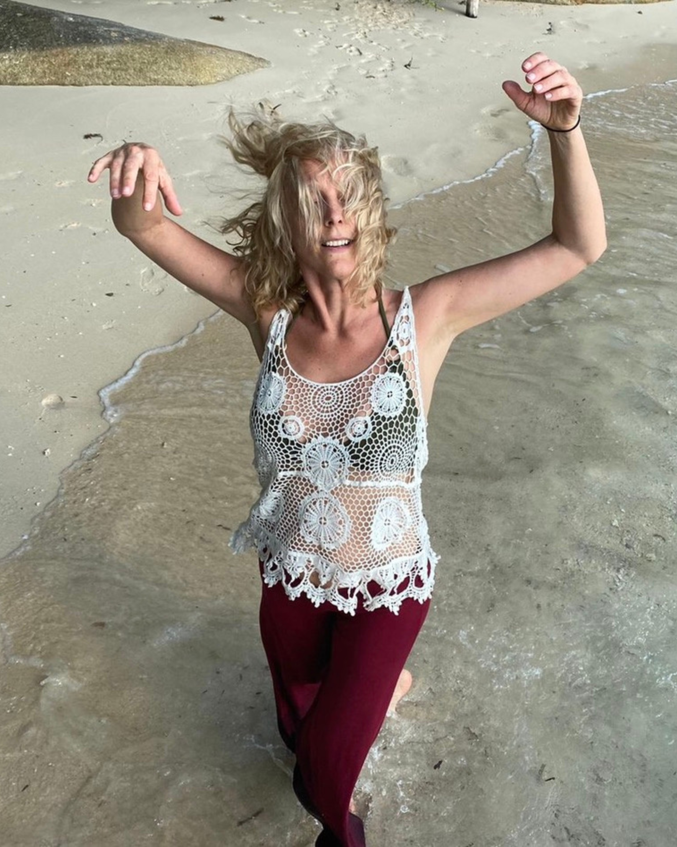 Annica Hill dancing with hair around face on the beach.