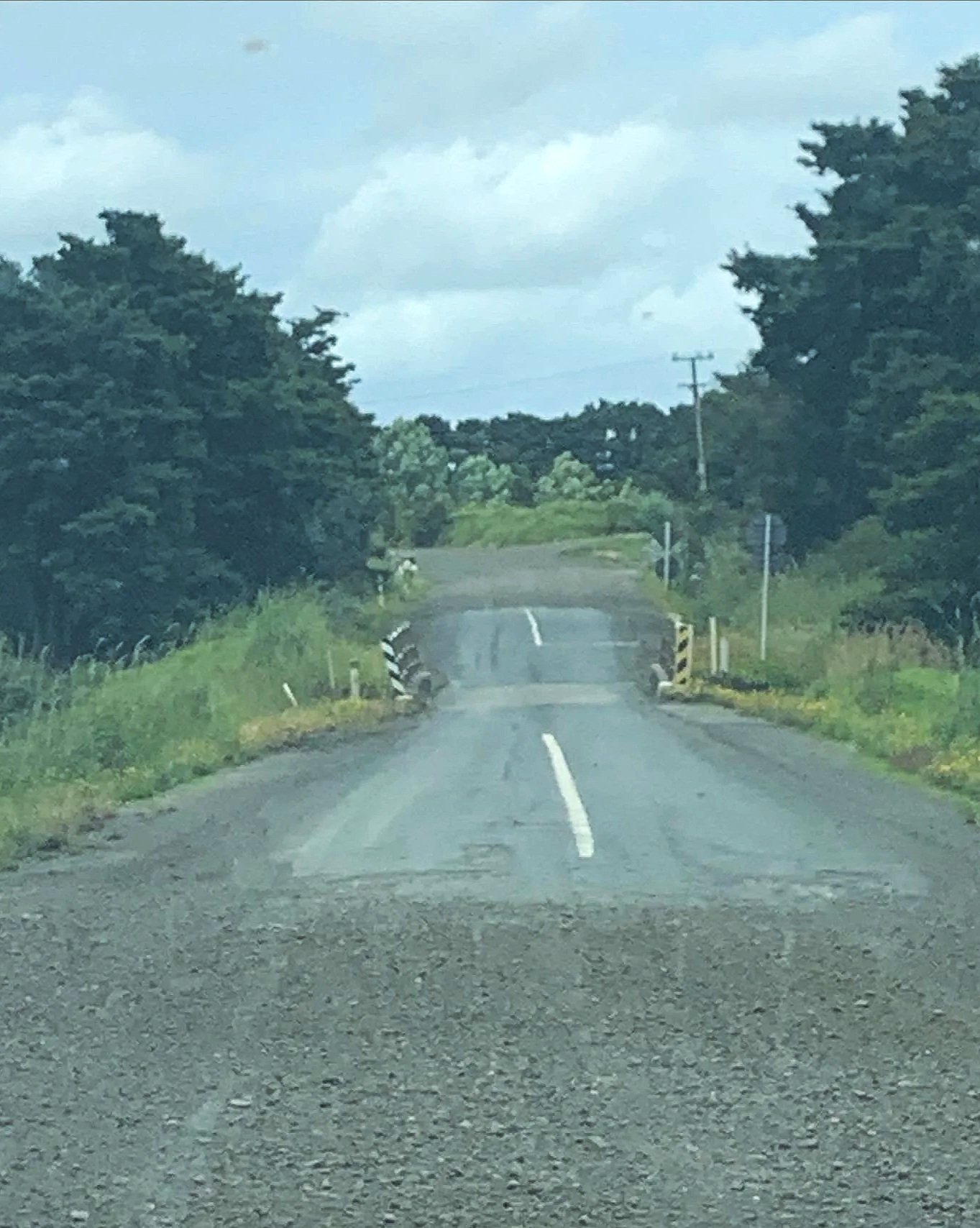 Gravel road, with a portin of sealed lined road then corcrete bride, then sealed road back to gravel. On a road leading to 90 Mile Beach