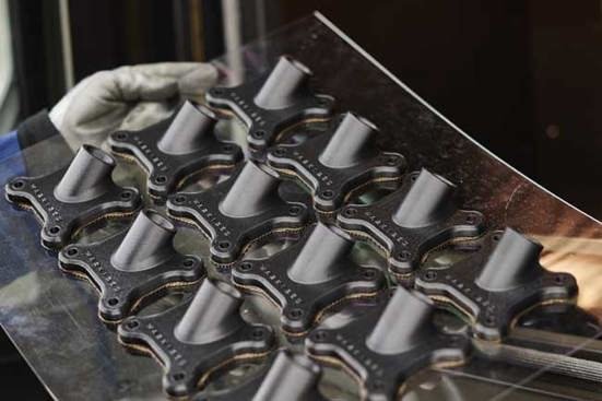Multiple metal bicycle hub shells placed on a table with a gloved hand nearby.