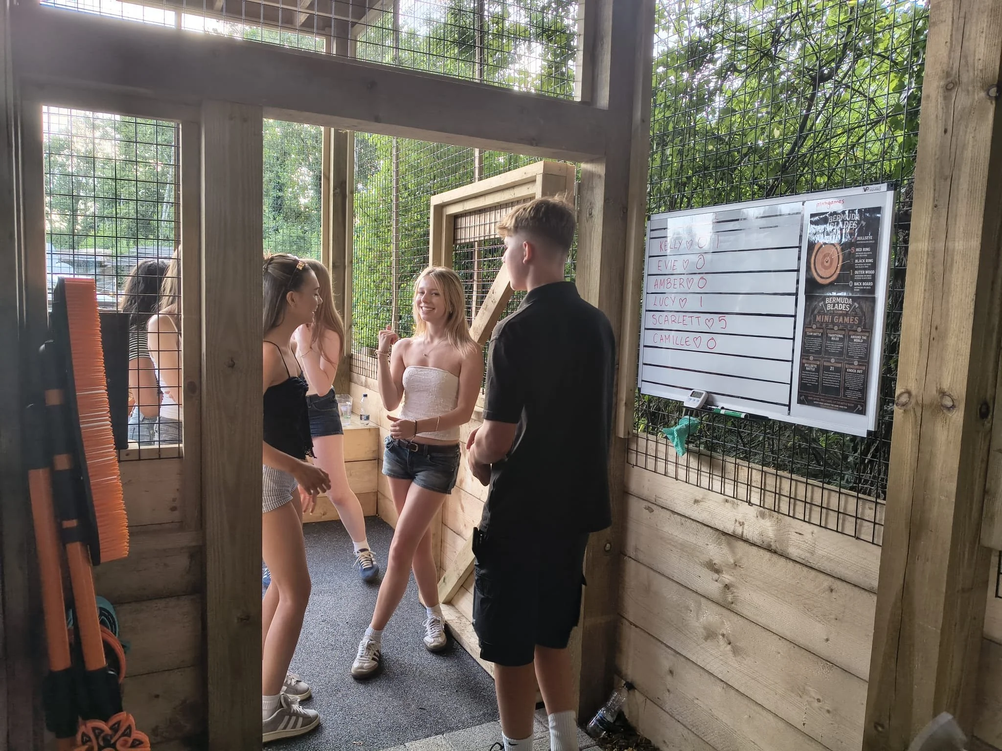 Group celebrating during a covered outdoor axe throwing session at Bermuda Blades in Henlow.