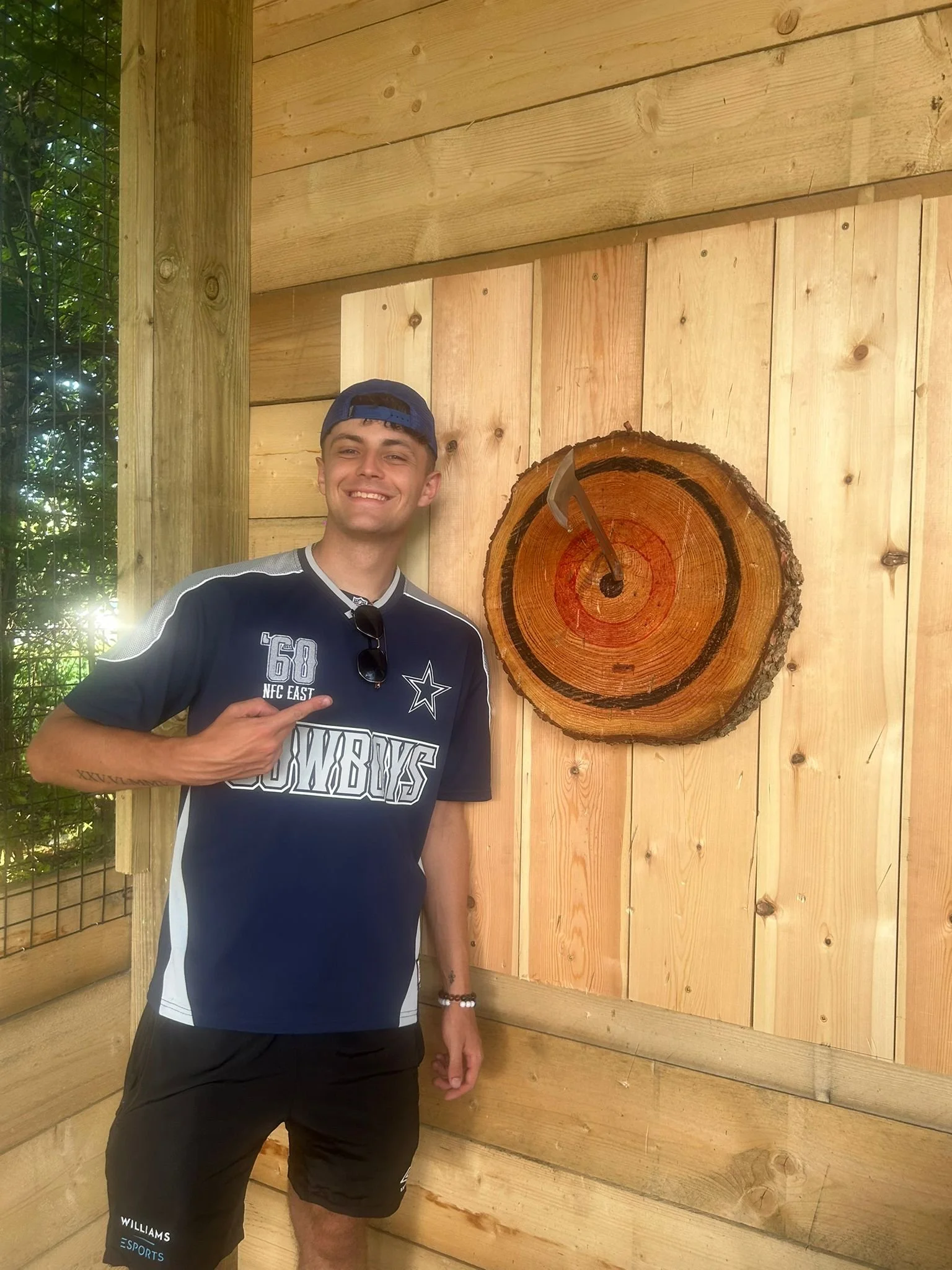 A participant enjoying axe throwing inside one of the covered outdoor lanes at Bermuda Blades in Henlow, Bedfordshire.