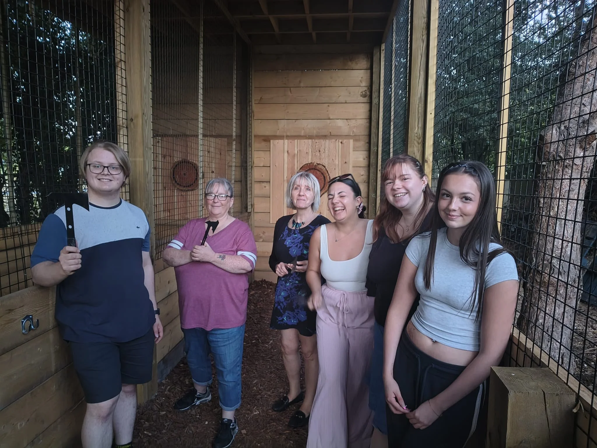 Six guests holding axes during a group session at Bermuda Blades