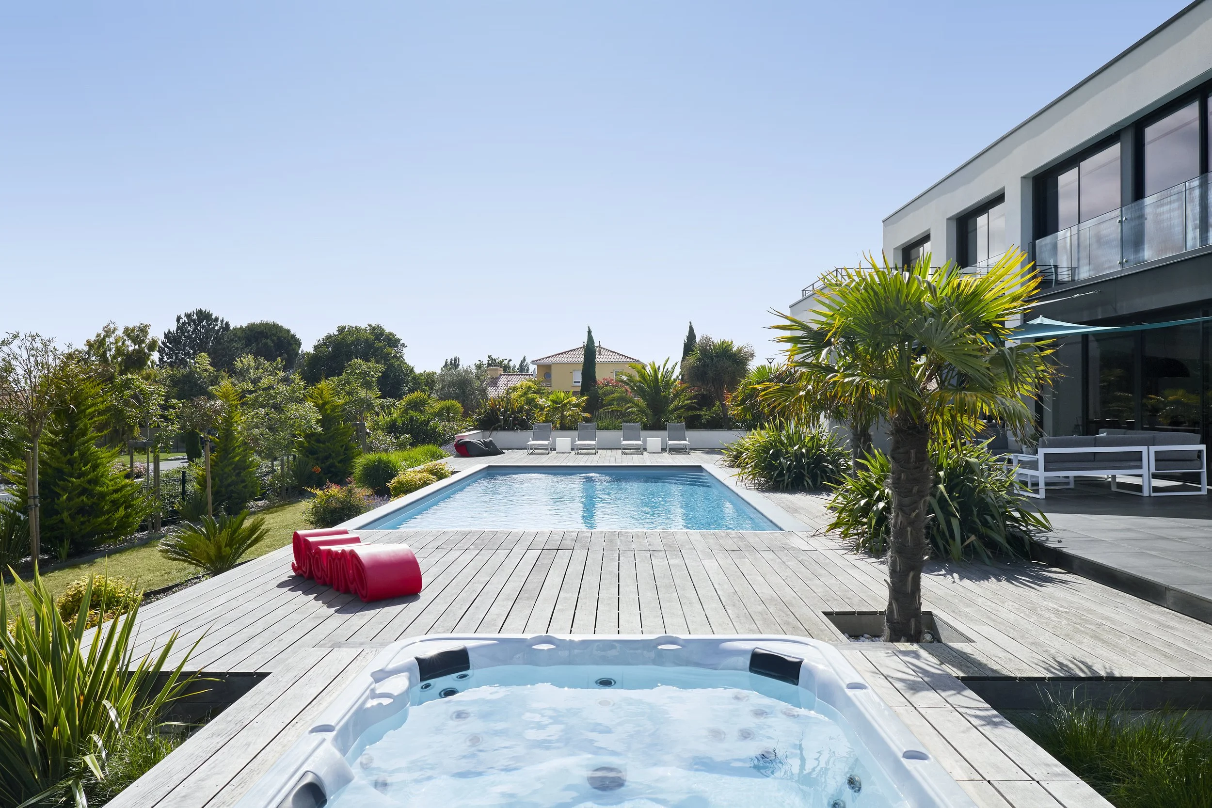 Terrasse de plain-pied, jacuzzi et palmiers — une villa conçue pour profiter pleinement du climat atlantique, dans un cadre intimiste et végétalisé.