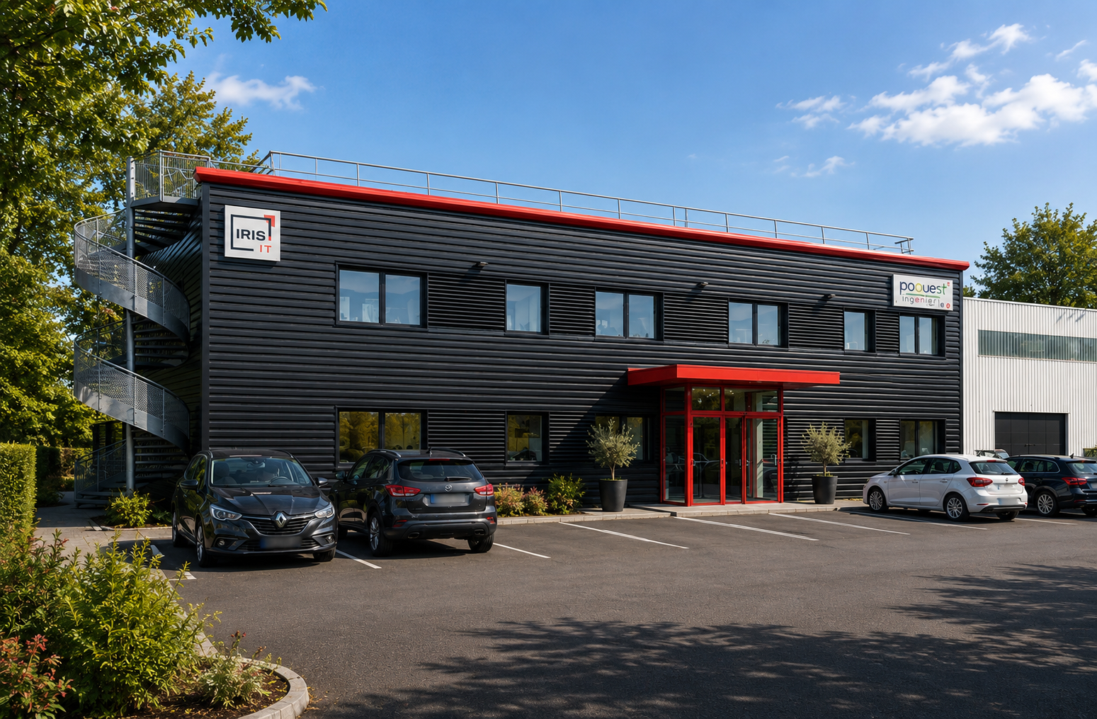 Bâtiment industriel – Réalisation – La façade en zinc noir et les accents rouges structurent l'identité visuelle de ce site d'activité, alliant robustesse et lisibilité architecturale.
