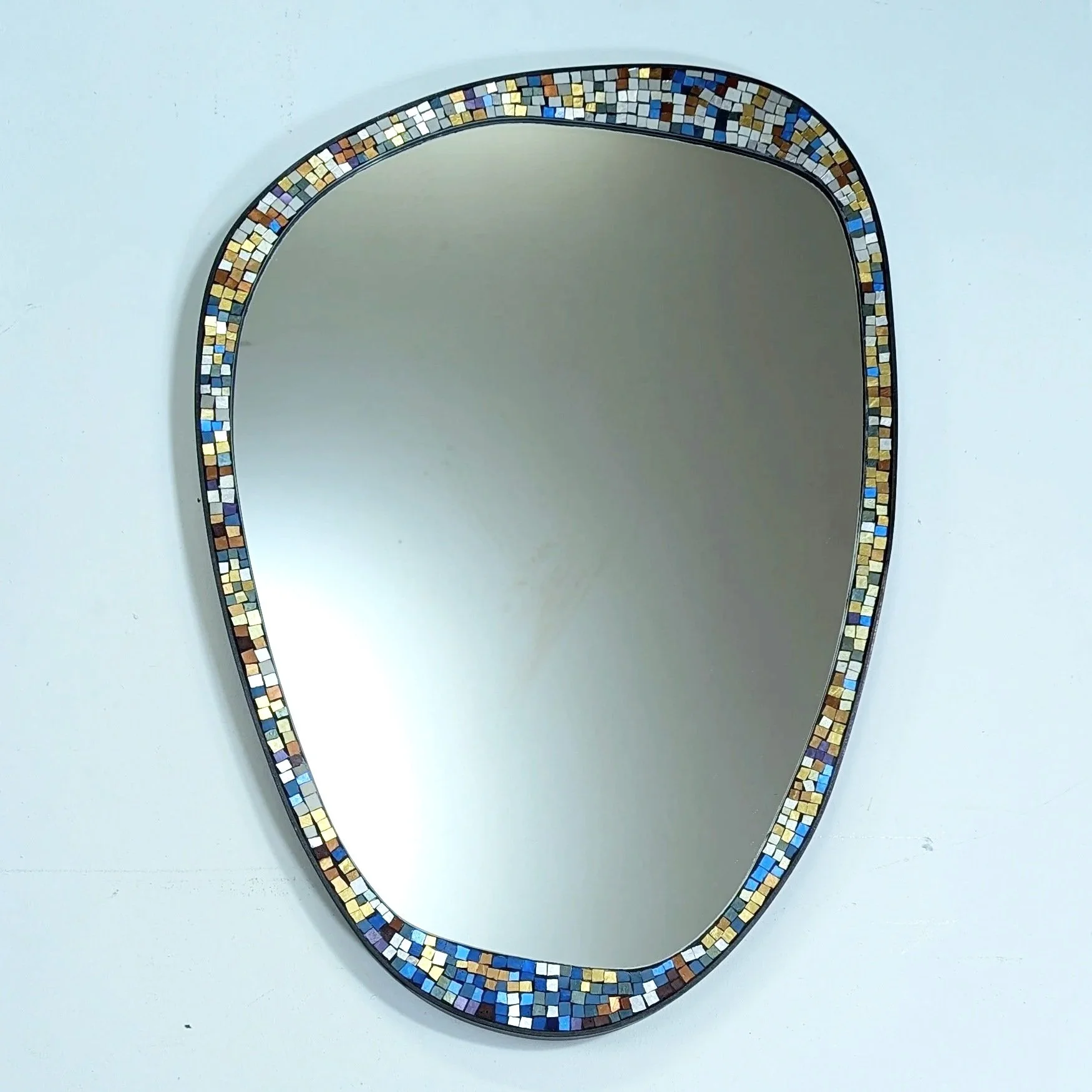 Miroir de forme ovale avec cadre décoré de mosaïques de petites pierres colorées.