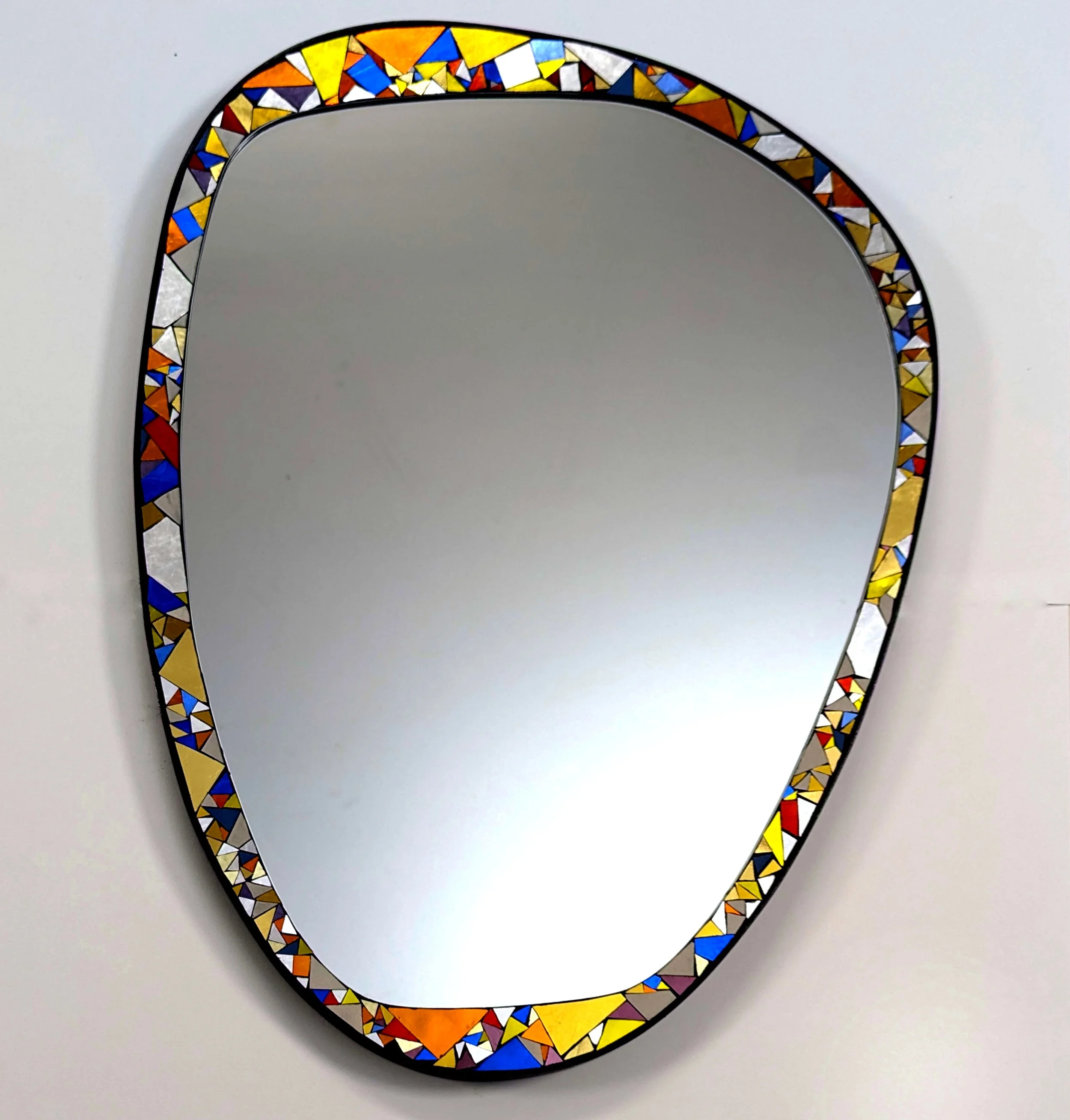 Miroir rond avec cadre en mosaïque de couleurs.