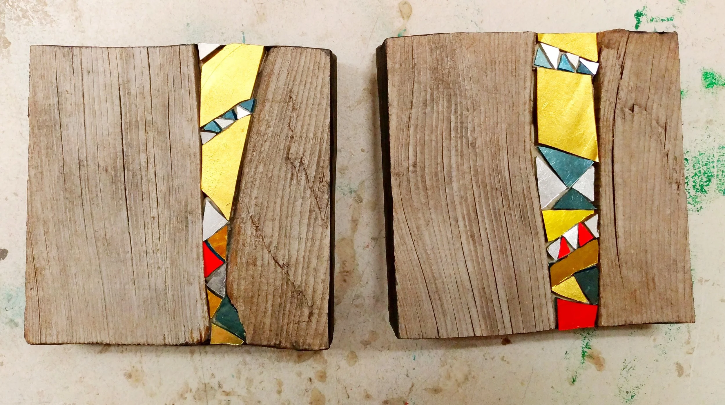 Deux morceaux de bois avec des mosaïques colorées collées sur leurs bords.