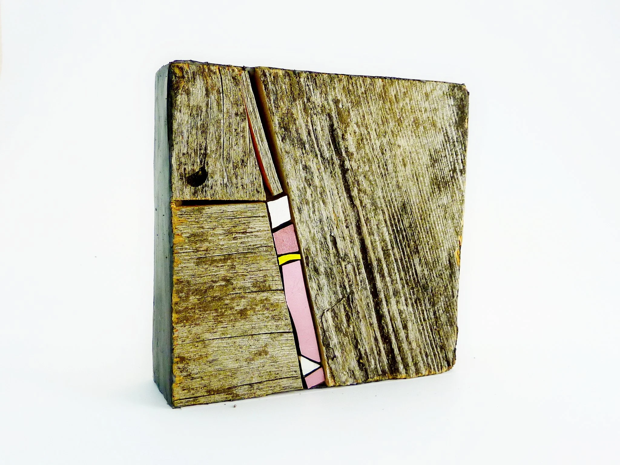 Bijou mural en mosaïque, une planche de bois rectangulaire avec des motifs colorés de papier collé visible sur un fond blanc.