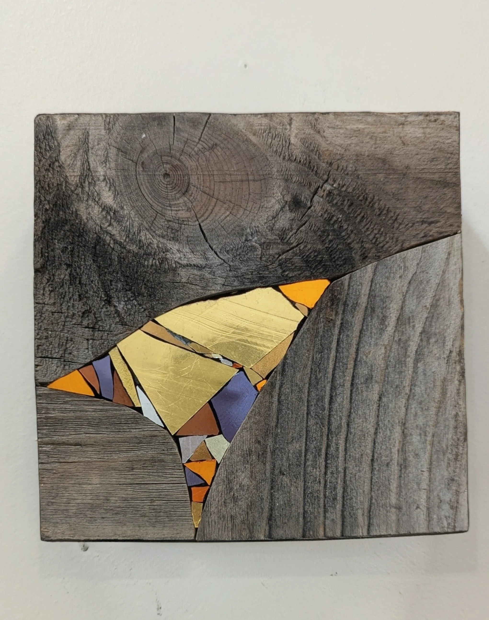 Montage de morceaux de bois avec un dessin en mosaïque représentant un colibri avec des couleurs vives