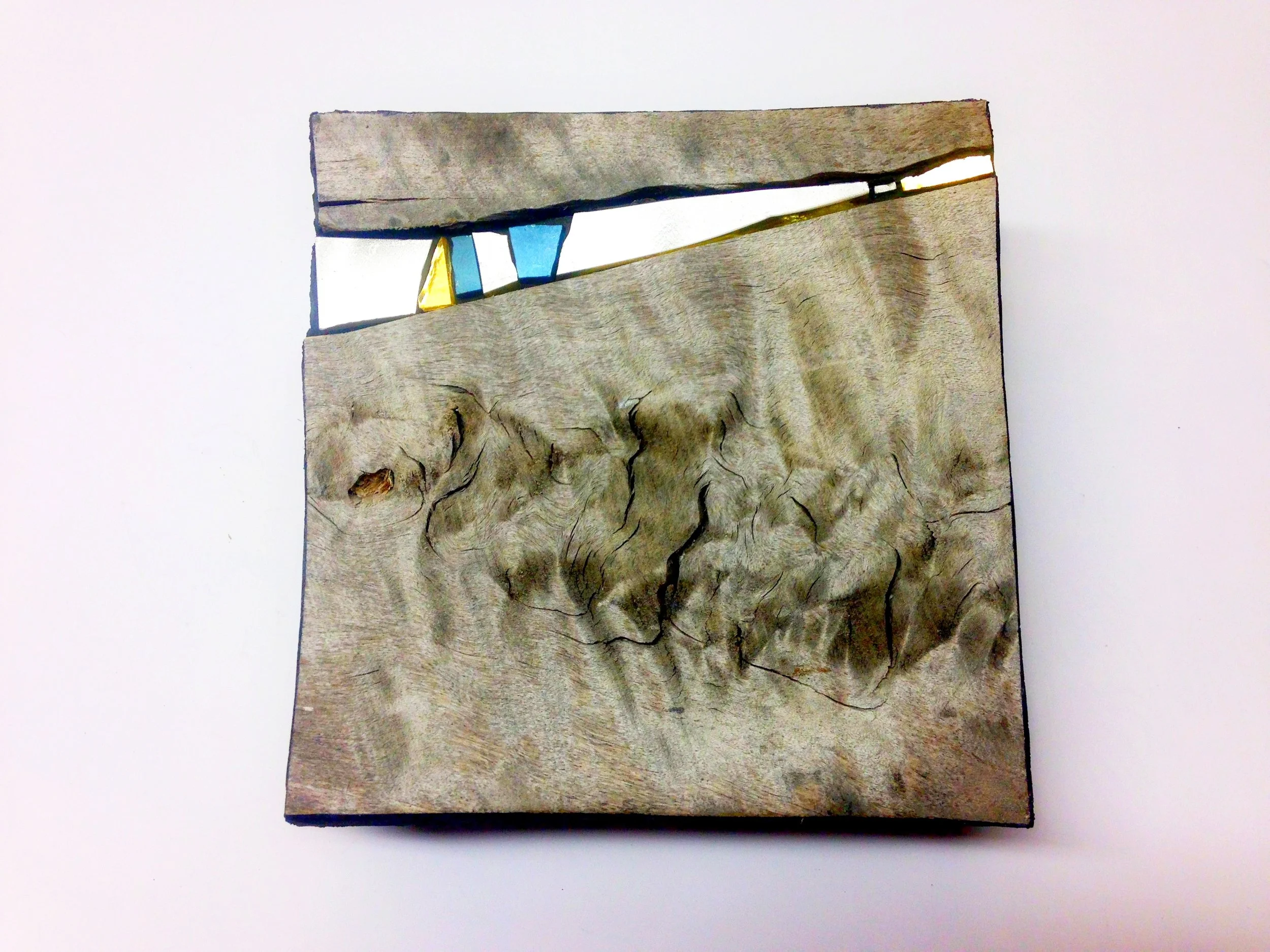 Un morceau de bois naturel avec des fissures et des textures, sur un fond blanc.
