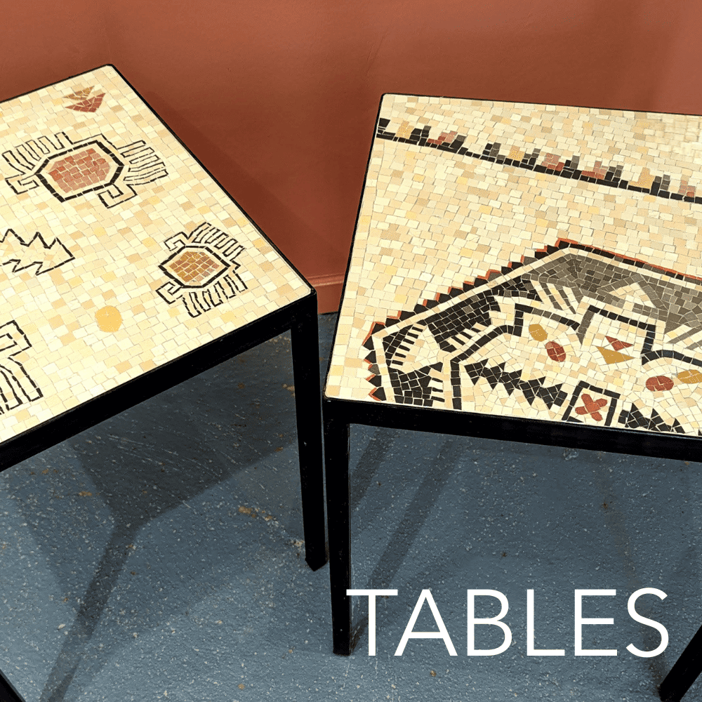 Deux tables en mosaïque avec des motifs géométriques et floraux, placées dans une pièce avec un mur marron et un sol en béton.