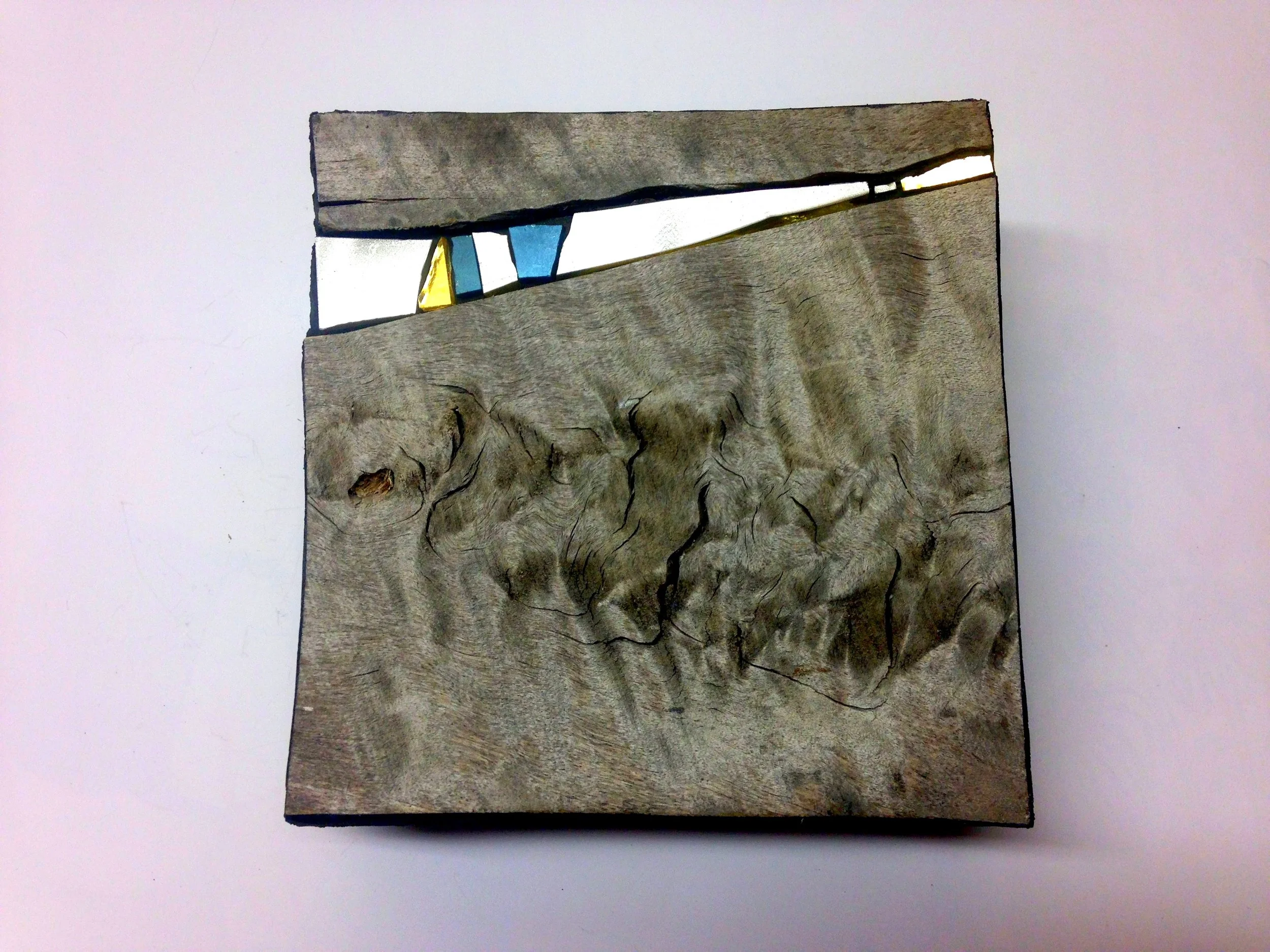 Tablette en bois avec des incrustations colorées.