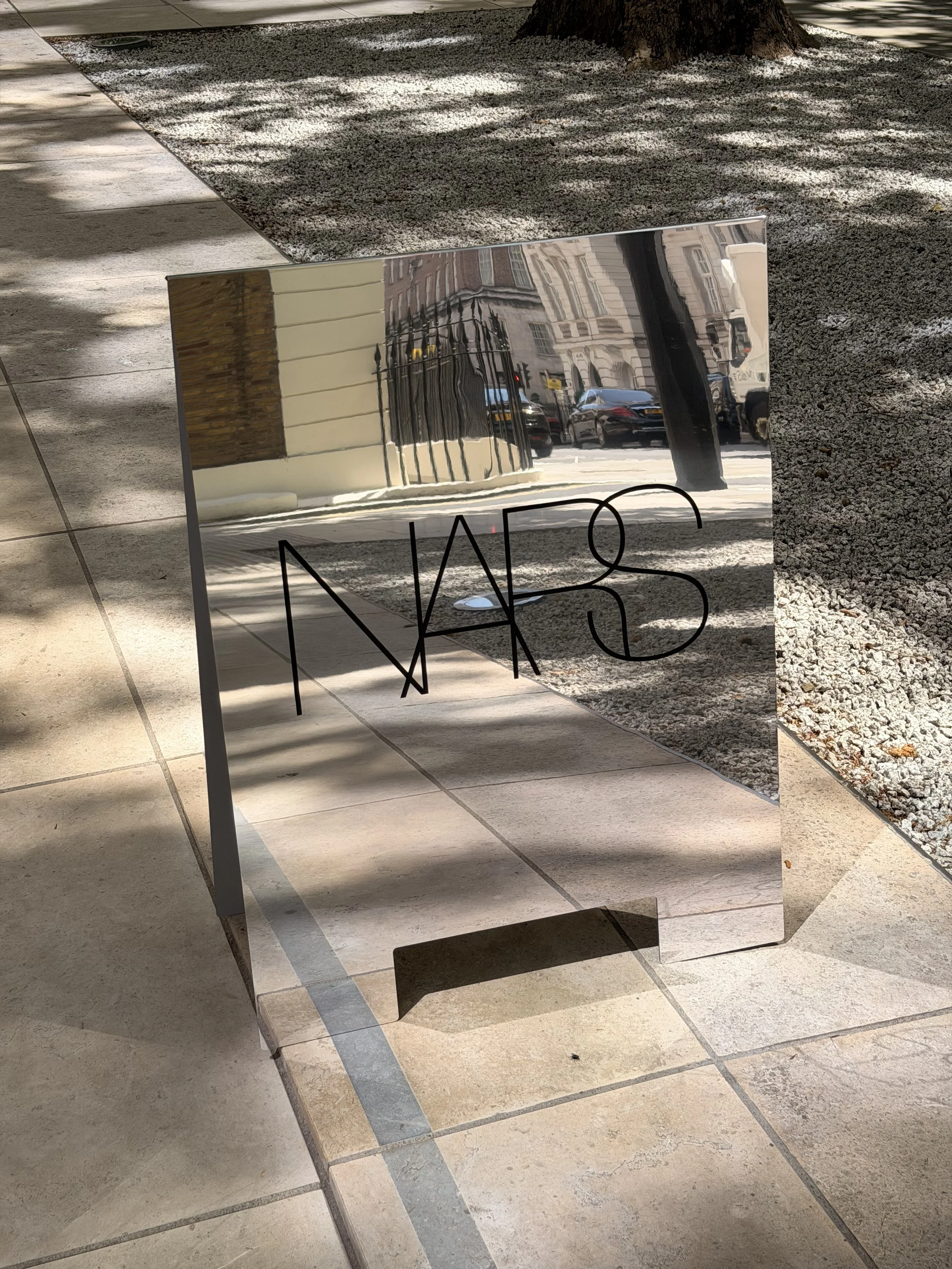 A reflective metal sign with the NARS logo