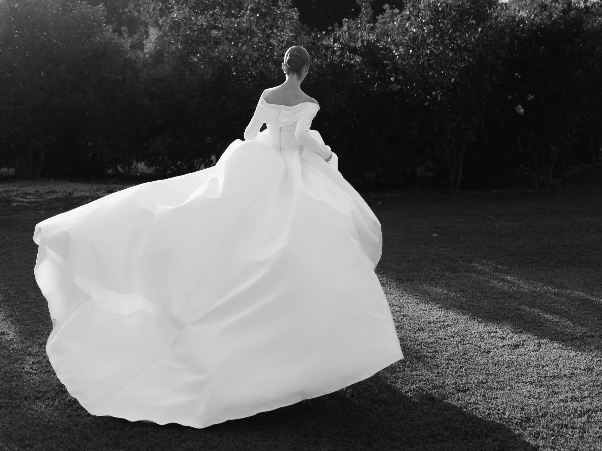 Bride in a strapless gown photographed from behind at an outdoor wedding - black and white wedding content creation