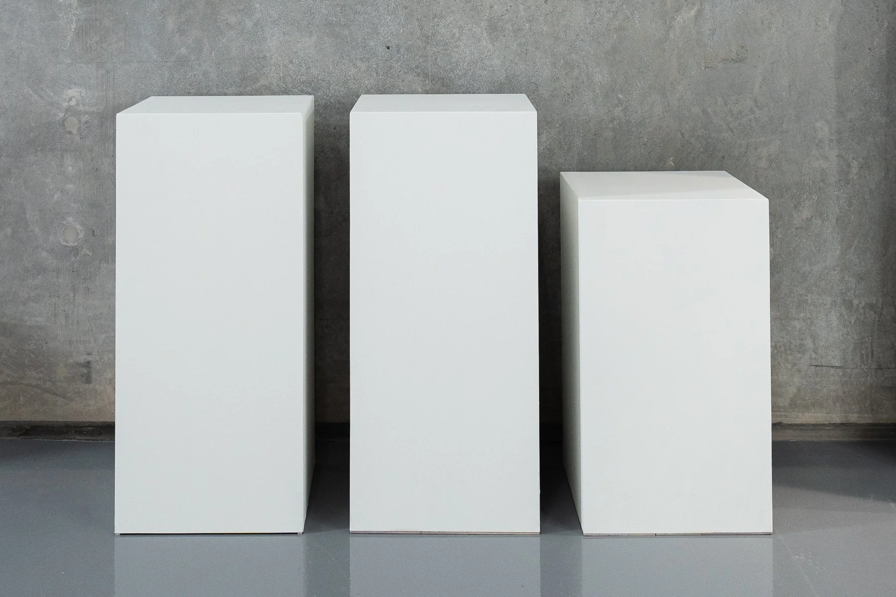 Set of three white rectangular display plinths — 2 × 90 cm high and 1 × 75 cm high. Suitable for product photography, fashion styling, posing and set design.