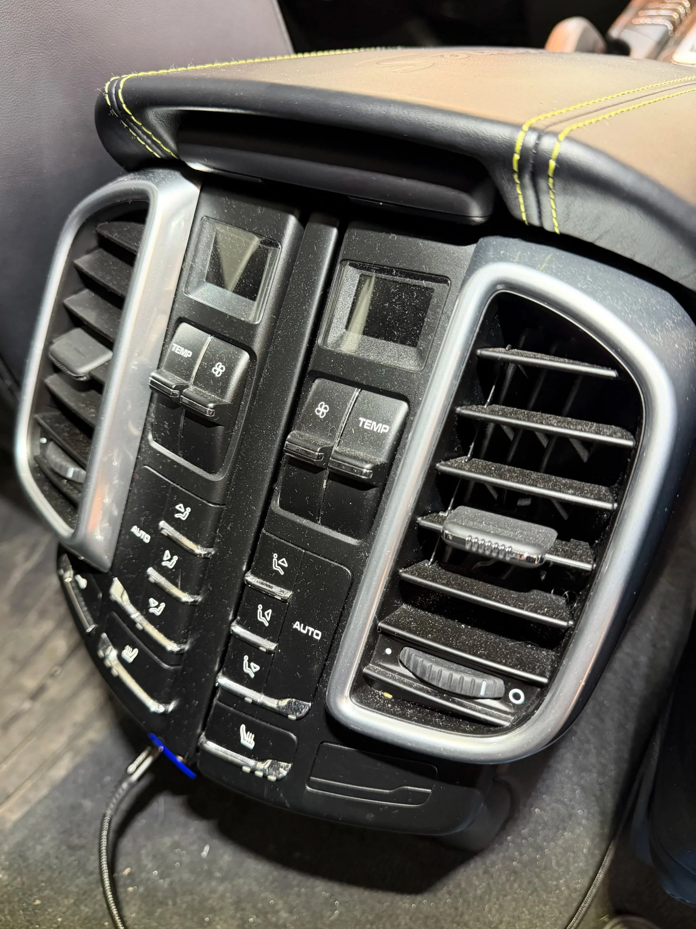 Car dashboard center console with air vents and climate control buttons. dirty