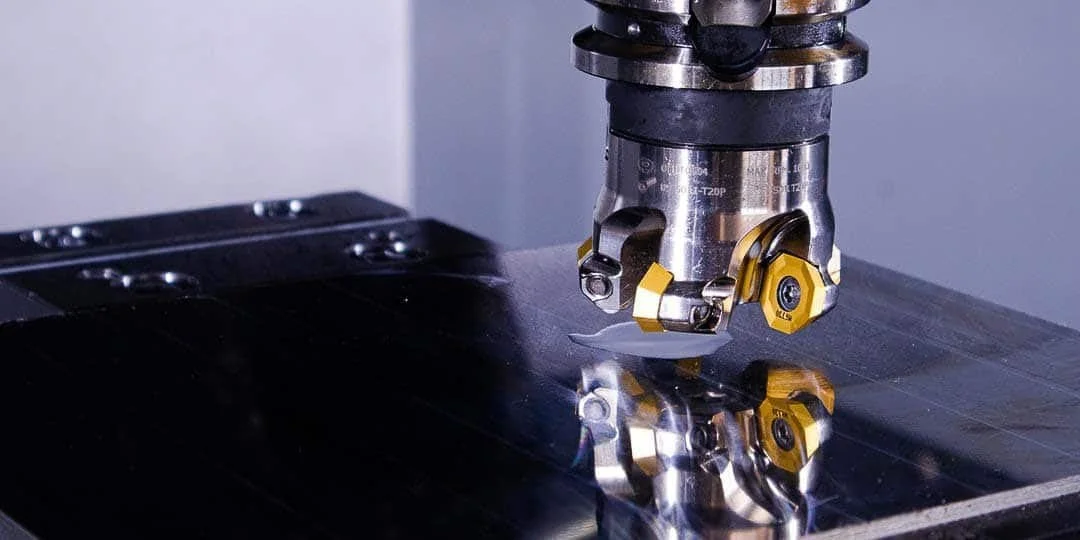 Close-up of a CNC machine cutting a reflective metal surface.