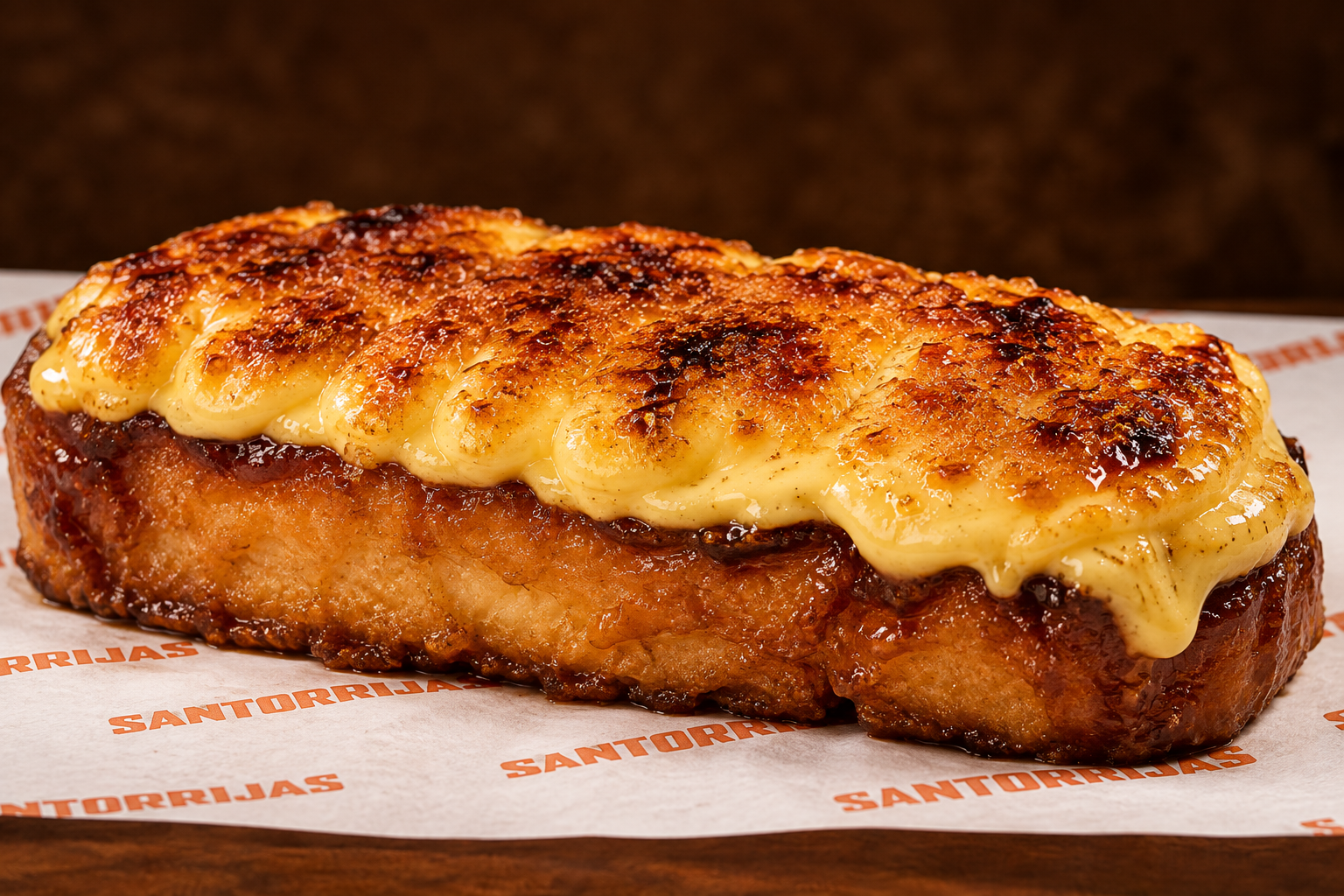Porción de pollo empanizado con queso gratinado en la parte superior, en un plato con papel decorativo que dice 'Santorrias' en letras naranjas.