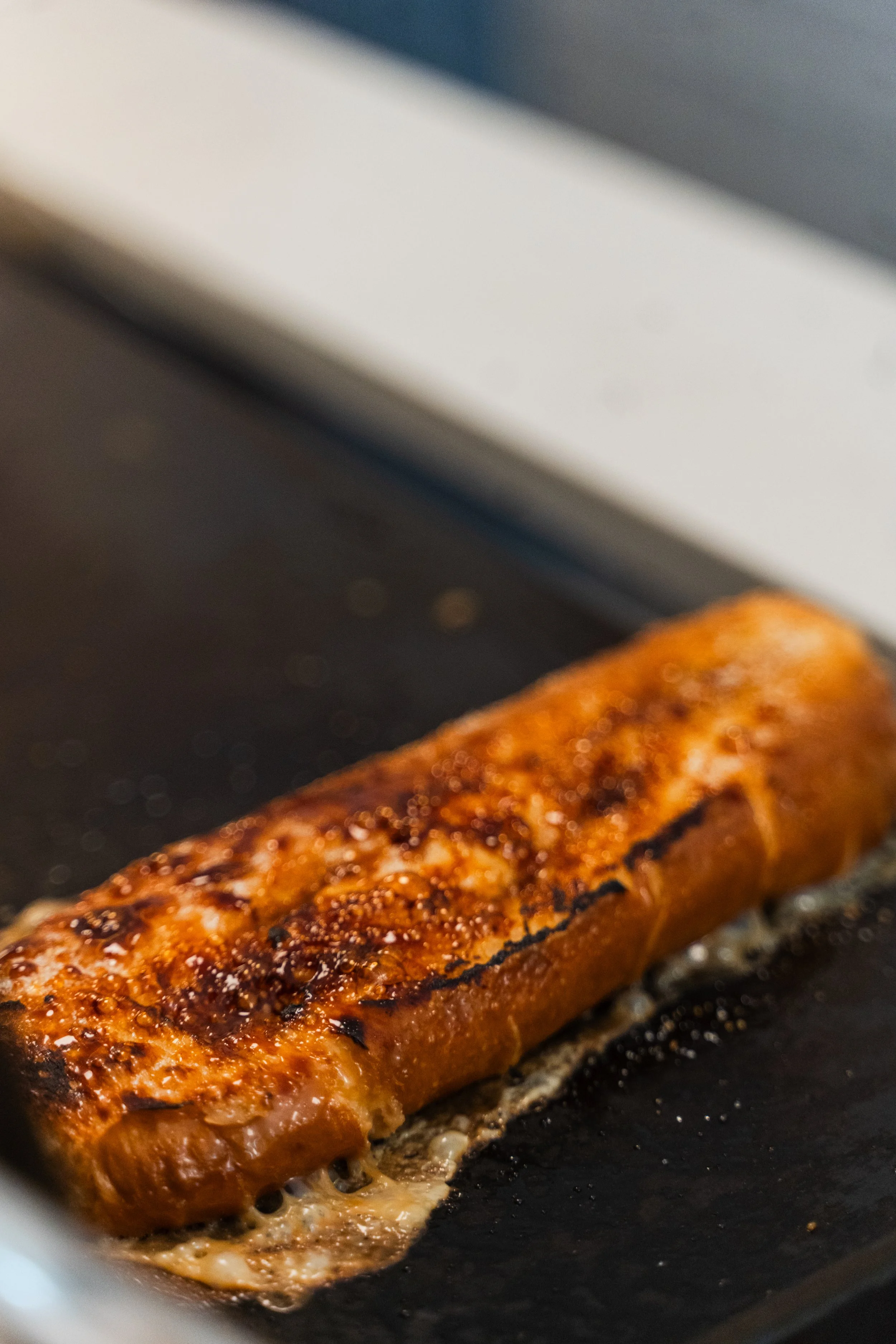 Un filete de salmón a la parrilla en una sartén, cocinado con especias y glaseado con una salsa brillante.