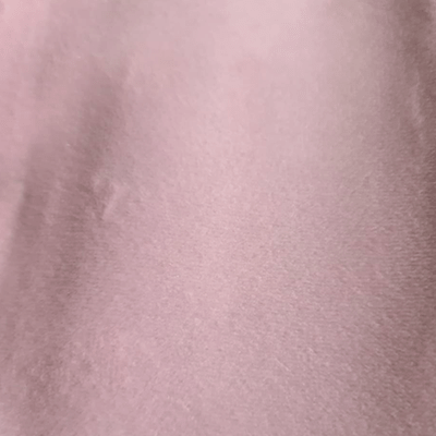 Close-up of a pink fabric surface with slight texture.