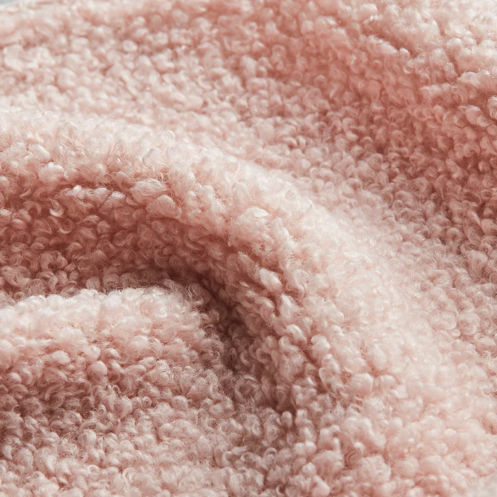 Close-up of a soft, pink, textured fleece fabric.