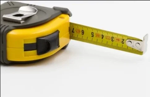 Close-up of a yellow and black tape measure extended to approximately 11 inches.