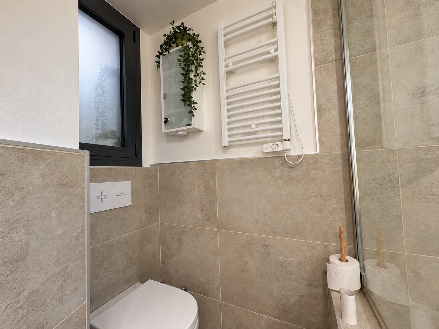 Baño moderno con plantas y vidrio velado.png