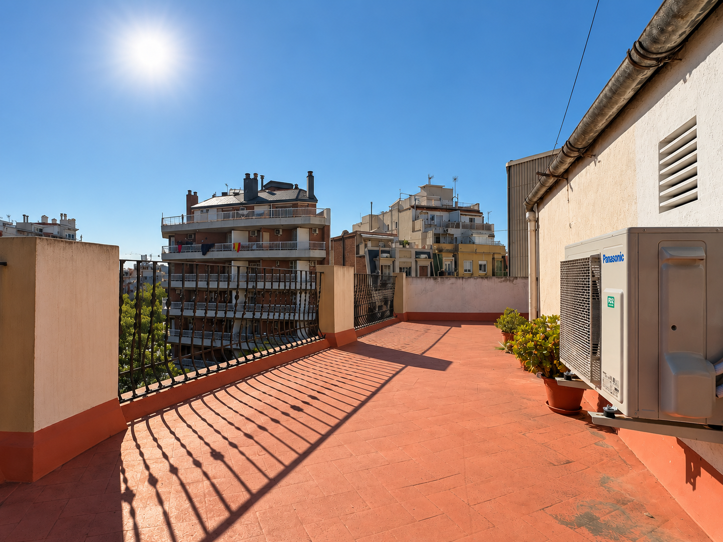 Terraza urbana soleada con edificios.png