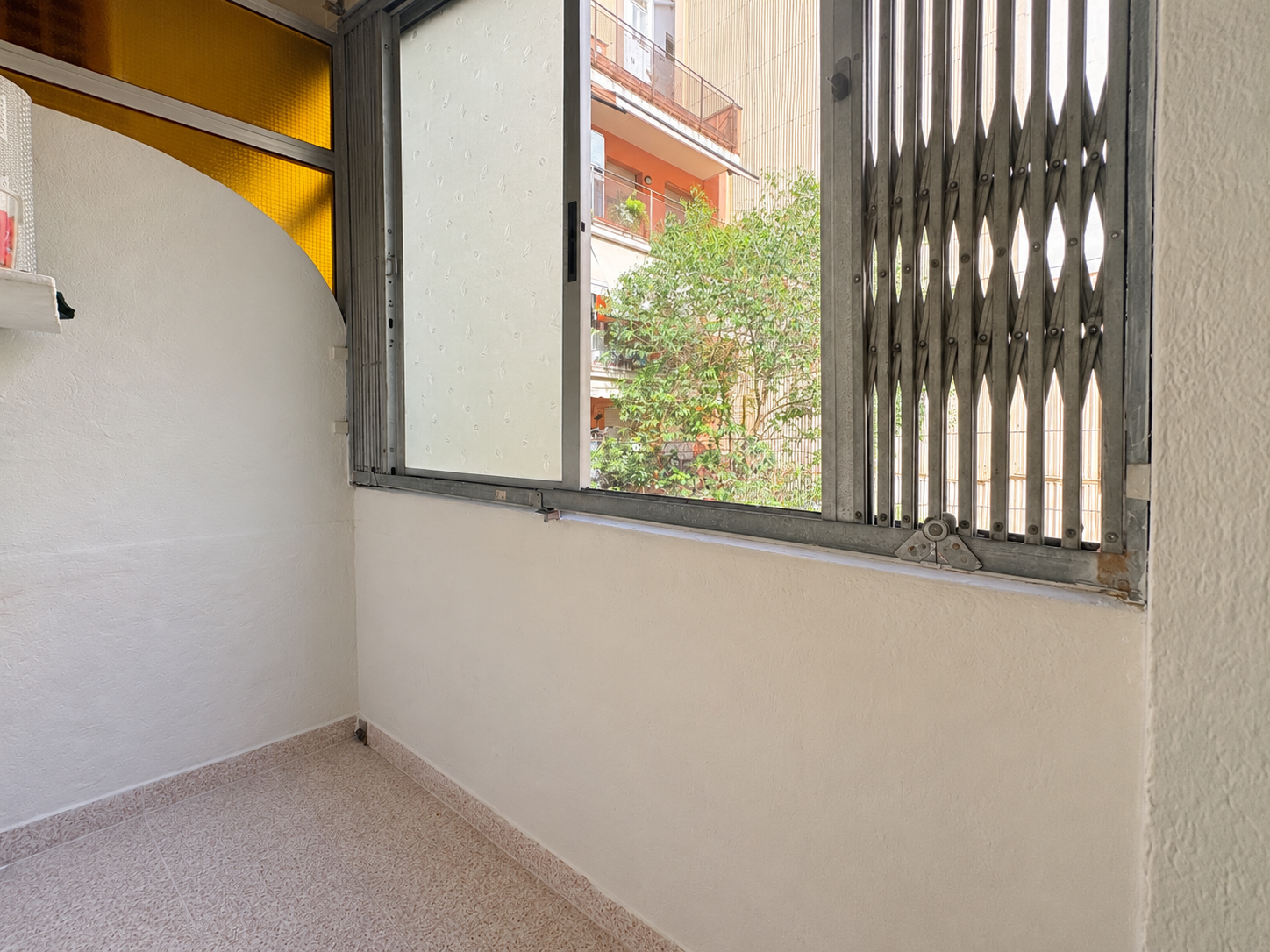 Balcón cerrado con ventana y rejilla.png
