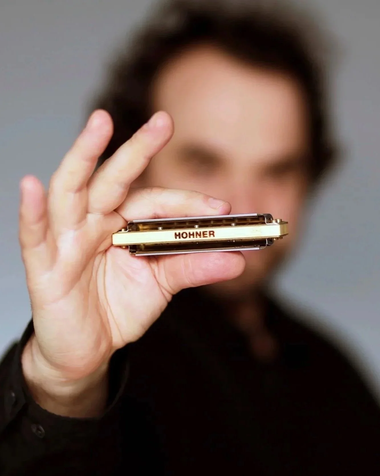 Marko Jovanović hält eine HOHNER Mundharmonika in die Kamera