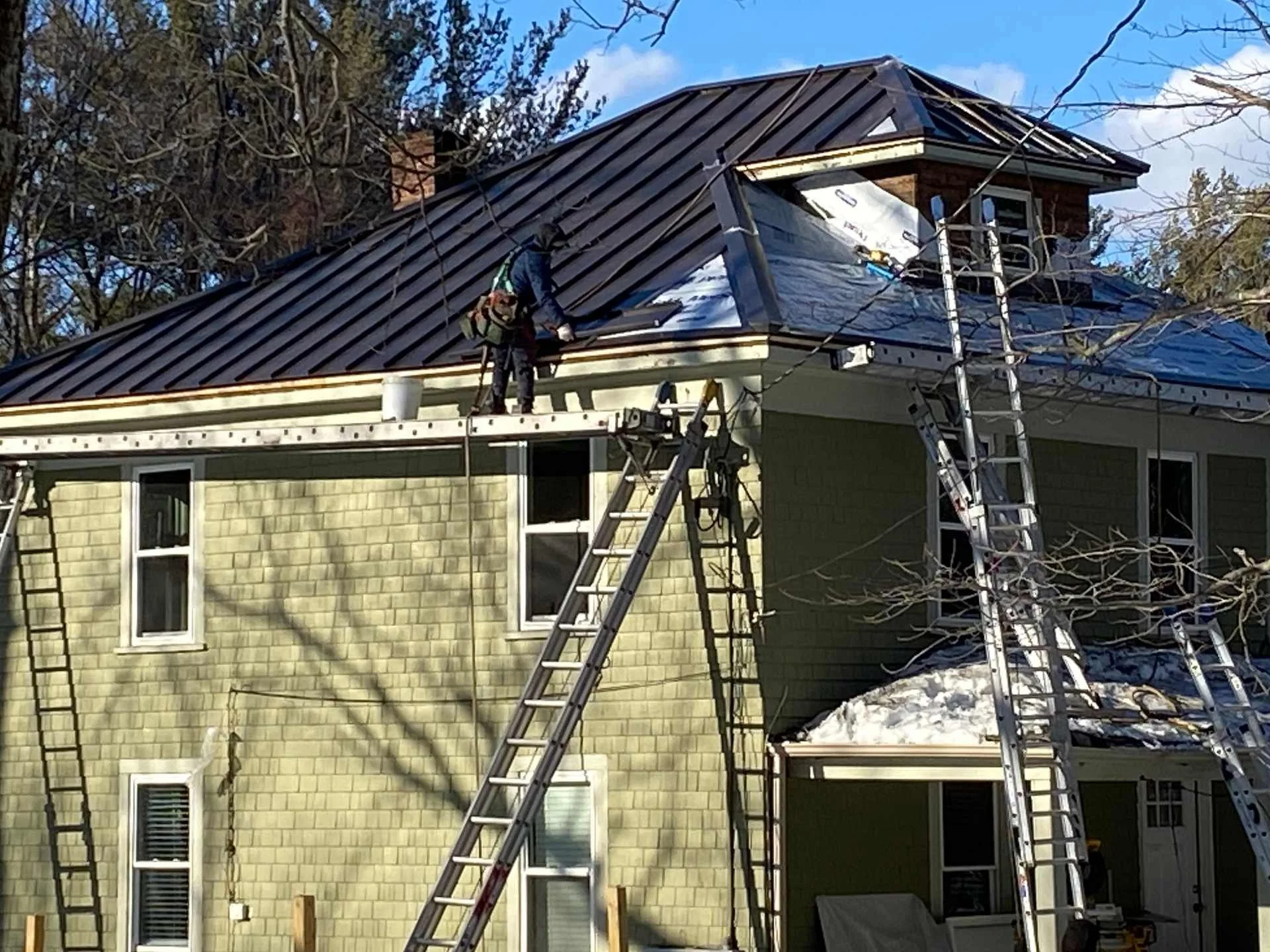 Man working on a roof in Massachusetts