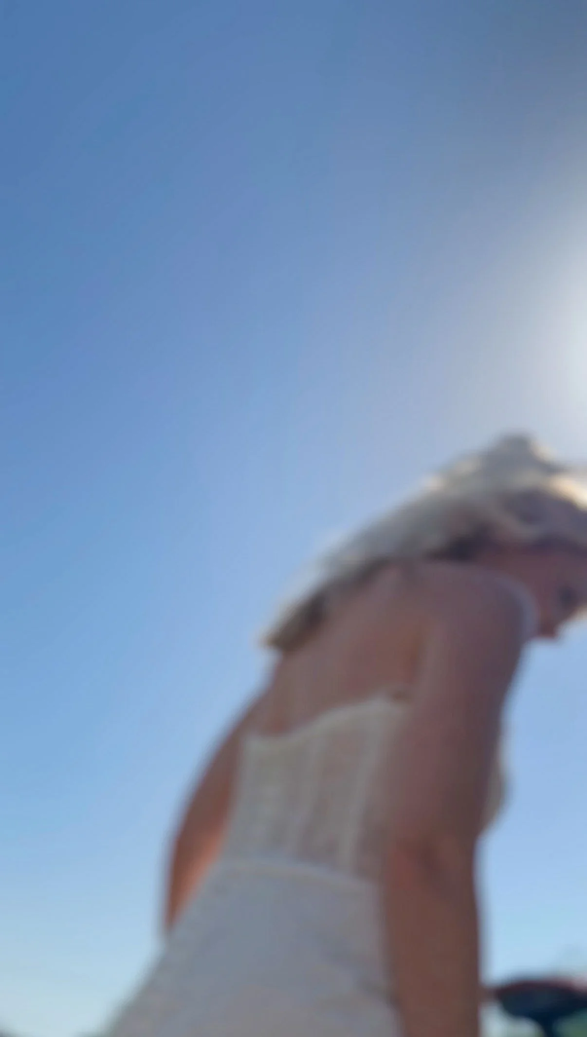 A blurry image of a bride in front of a blue sky