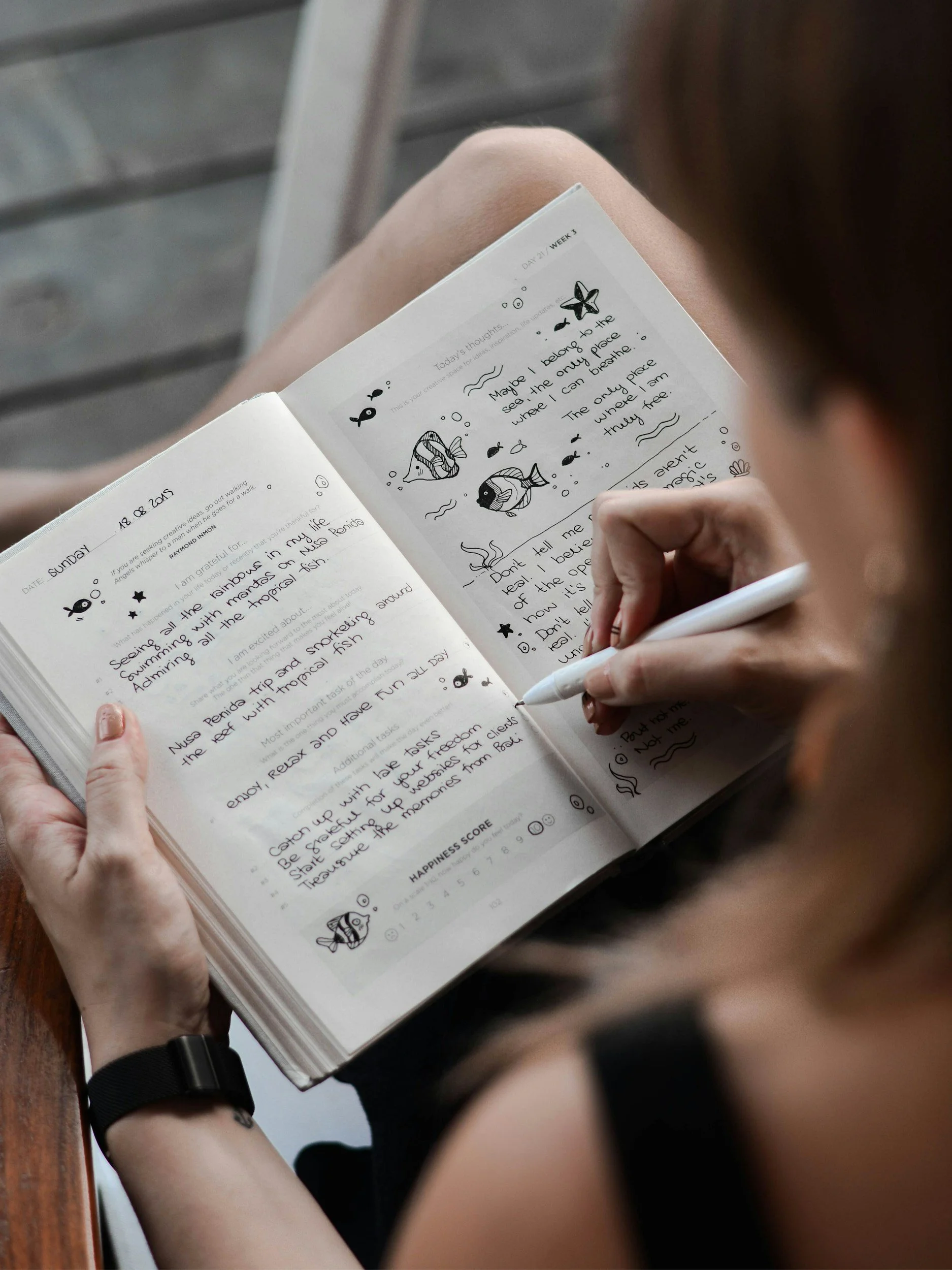 Person schreibt handschriftlich in ein Notizbuch – analoge Kreativität als Gegenpol zur digitalen Reizüberflutung.