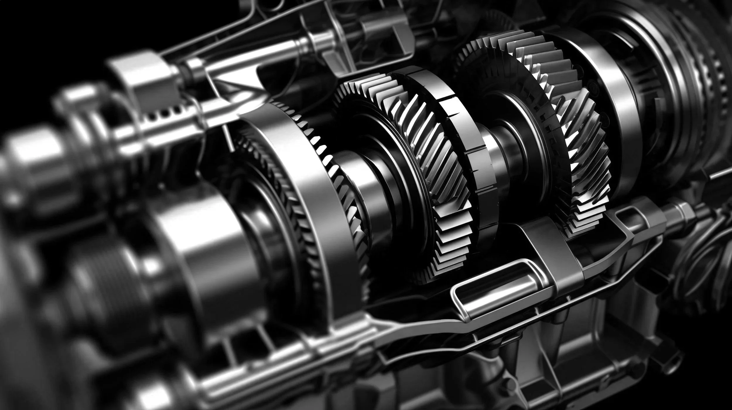 Close-up of a metallic mechanical gear assembly with multiple gears and components in black and silver.