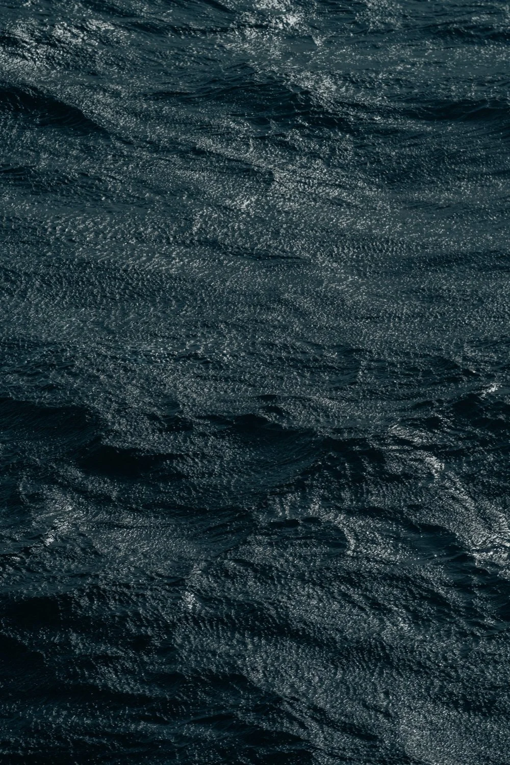 Aufnahme des Meeres mit dunklen Wellen und spiegelnder Wasseroberfläche