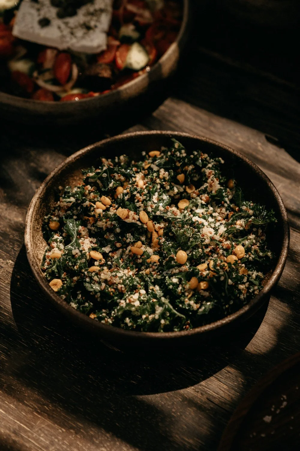 Schüssel mit Quinoa, Grünkohl, Kichererbsen und anderen Zutaten, auf Holz Tisch