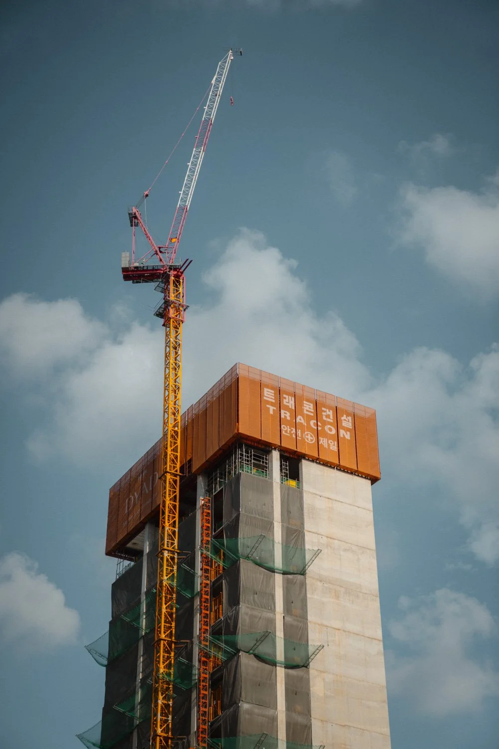 Baustelle mit Hochhaus und Baukran gegen den Himmel.