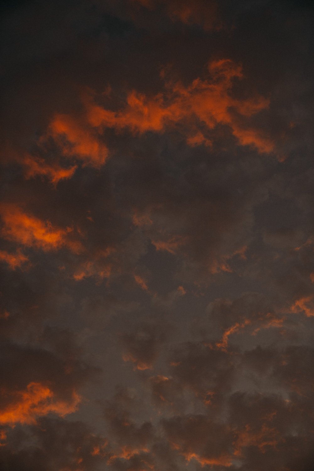 Abendhimmel mit dunklen Wolken und orange leuchtenden Wolkenstücken