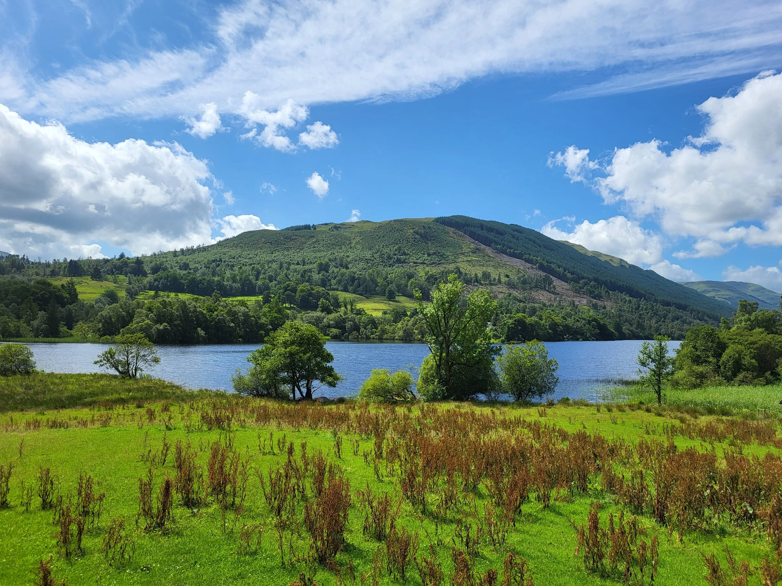 Scenic Scottish loch and green hillside — the big dream of land and slow living in Scotland