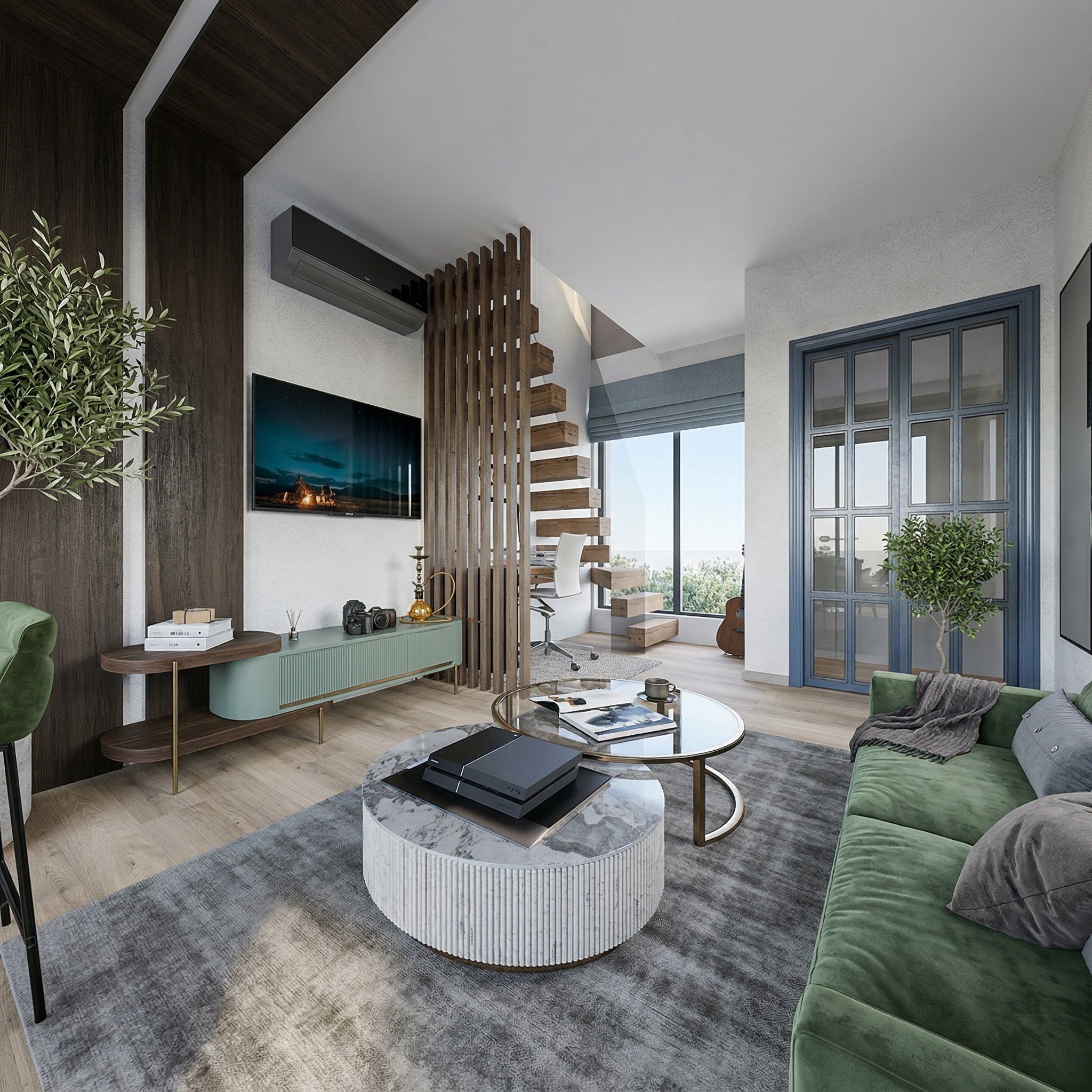 Compact Japandi mini loft living room with sage green velvet sofa, round marble coffee table, wooden slat staircase divider, wall-mounted TV and modern open kitchen in the background creating a functional, stylish open space