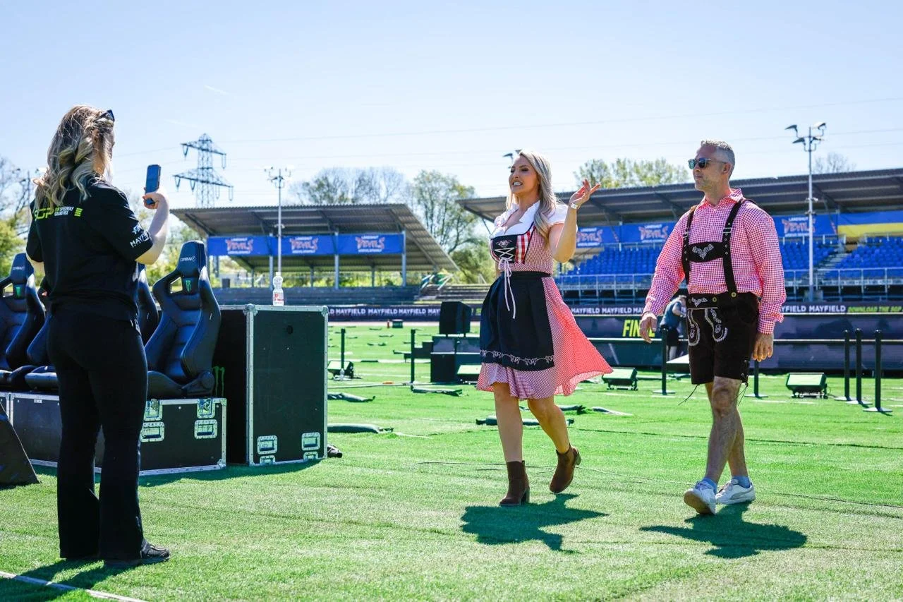 SpeedwayGP presenters in traditional Bavarian outfits walking on the in field, whilst I filmed them.