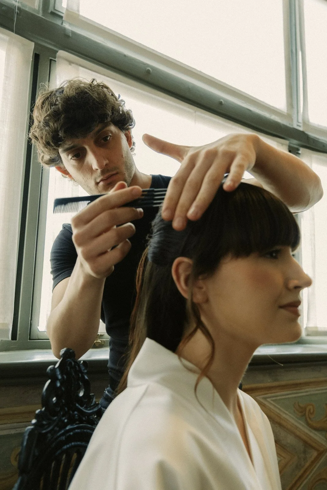 Wedding hairstylist preparing bride for luxury editorial photoshoot