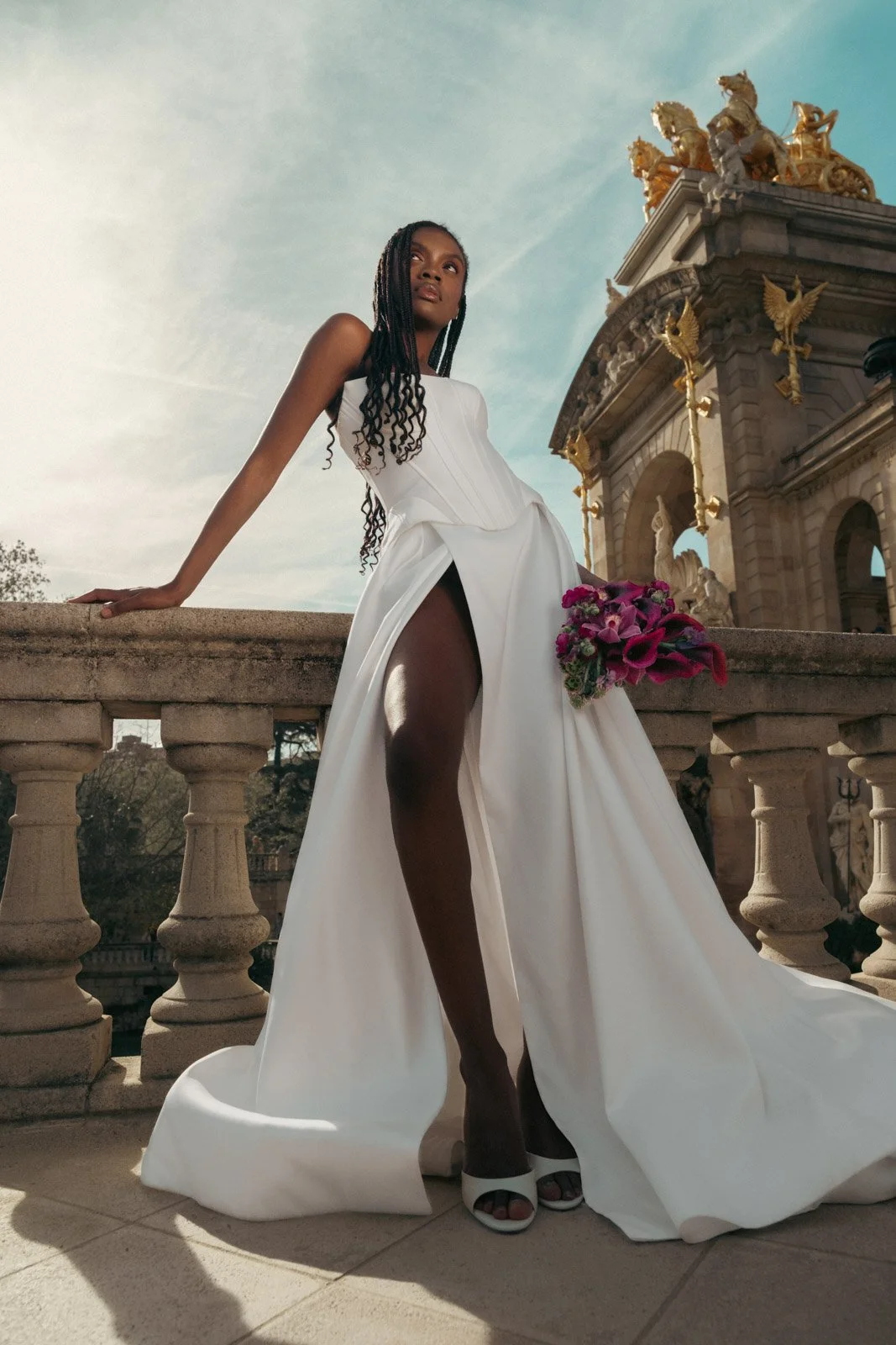 Bride posing on historic terrace during destination wedding editorial in Europe