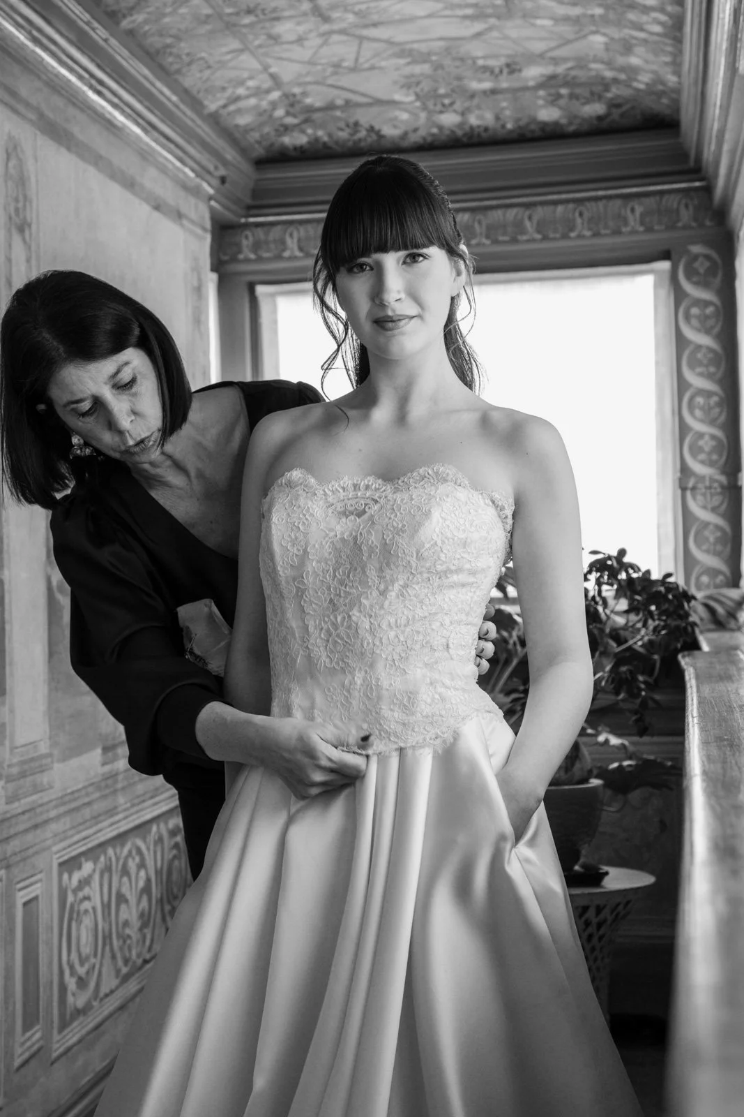 Bridal stylist adjusting couture wedding dress during editorial fashion shoot