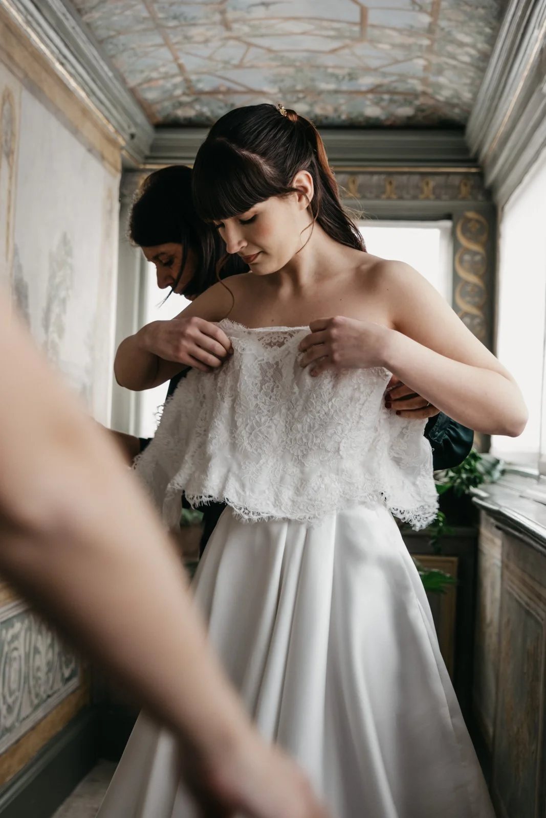 Bride getting dressed during intimate luxury bridal editorial session