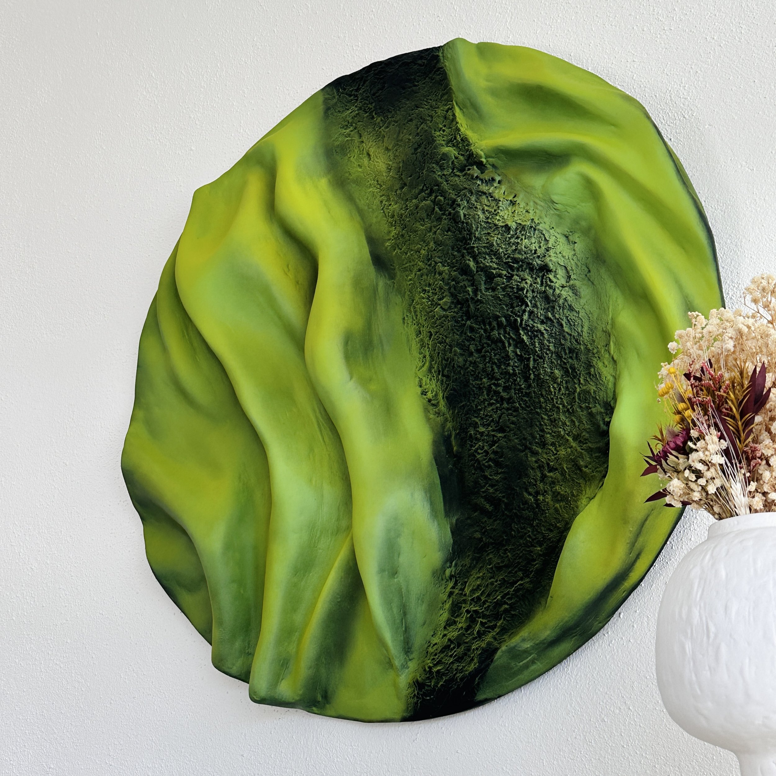 Green organic-inspired sculptural artwork with textured surface details