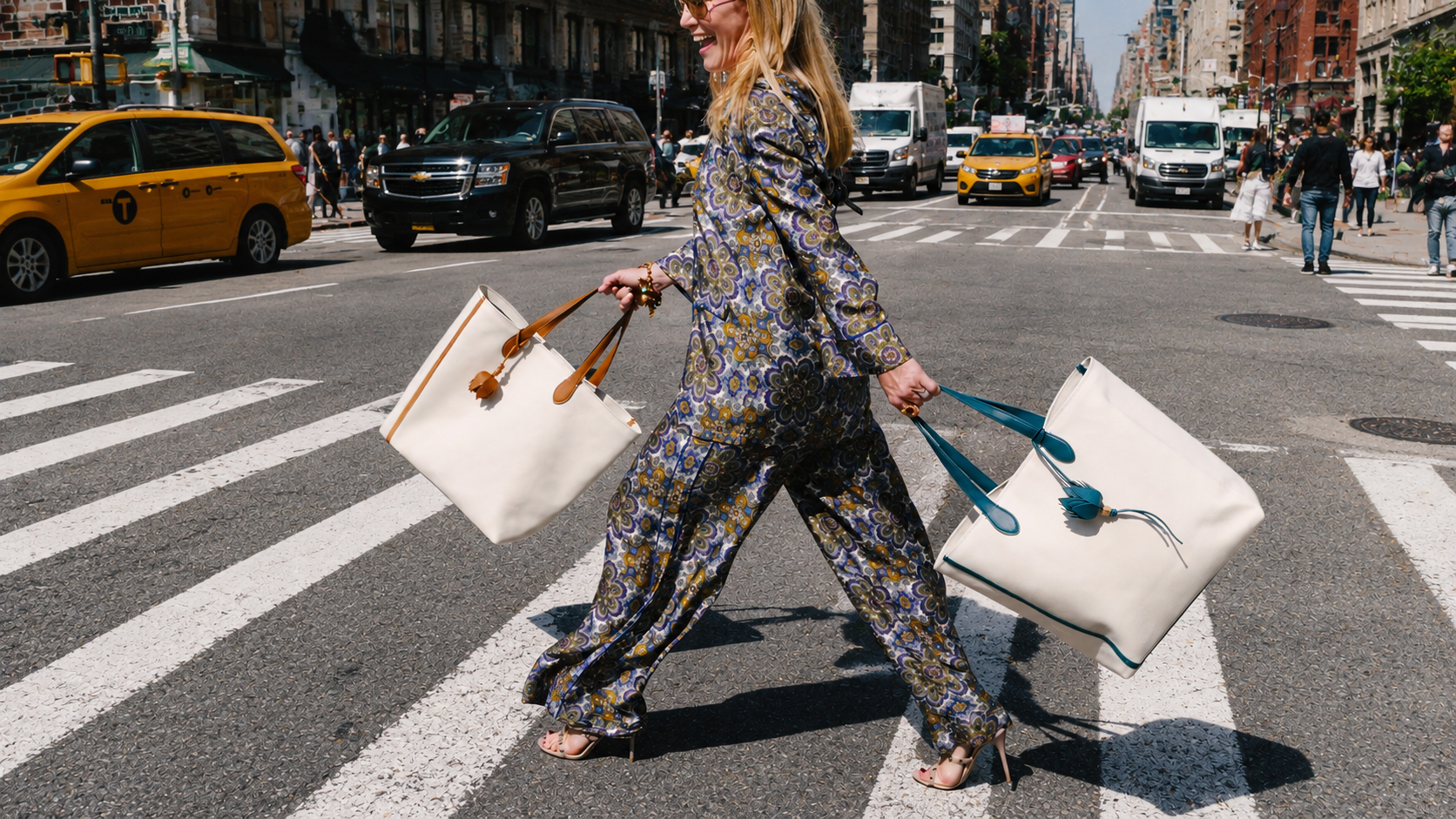 A woman crossing a busy city street at a crosswalk, carrying large white bags with brown and blue handles.