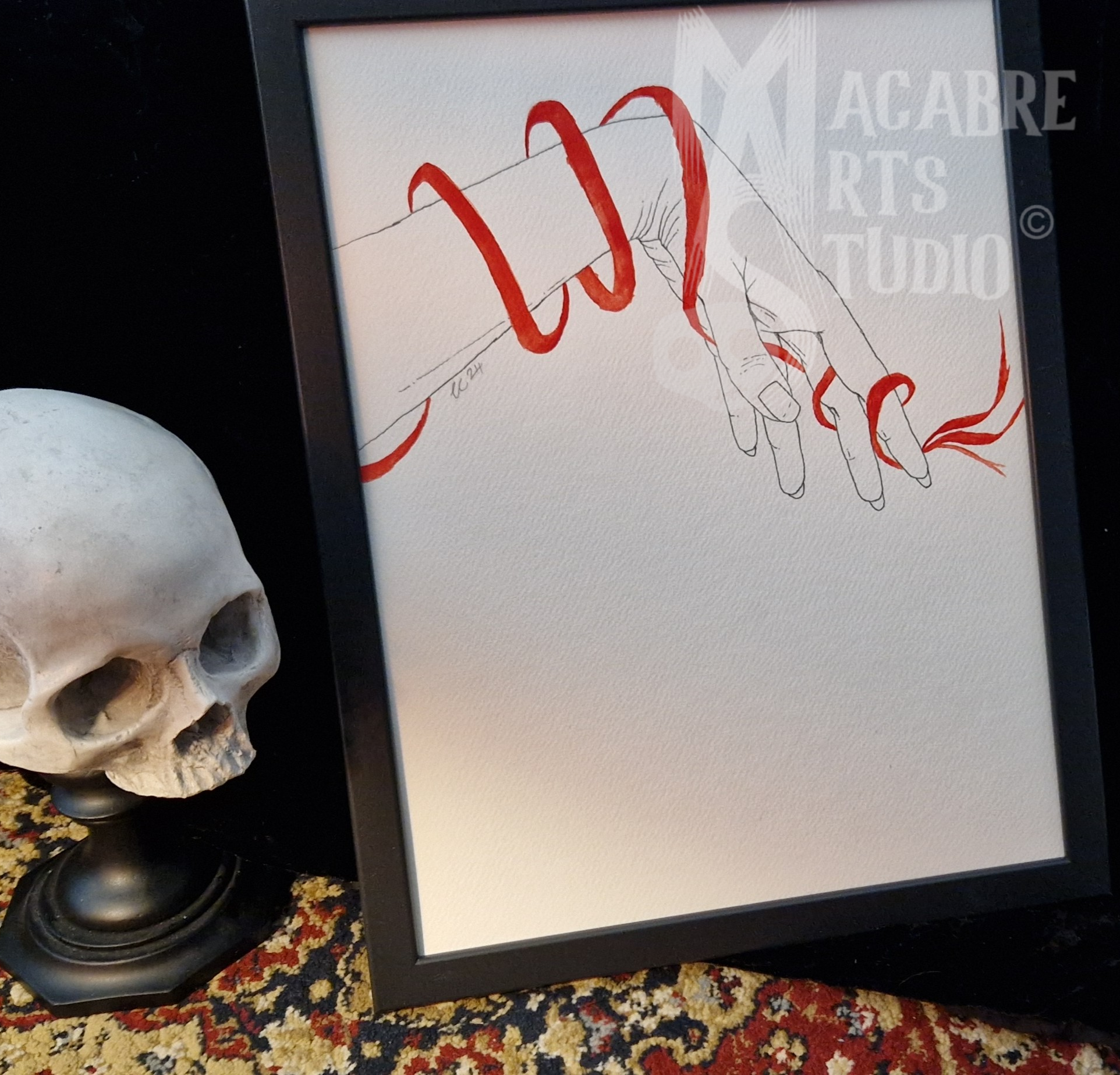 A framed artwork displaying a line drawing of a limply reaching hand being wrapped in red. Overlaid with copyright watermark.